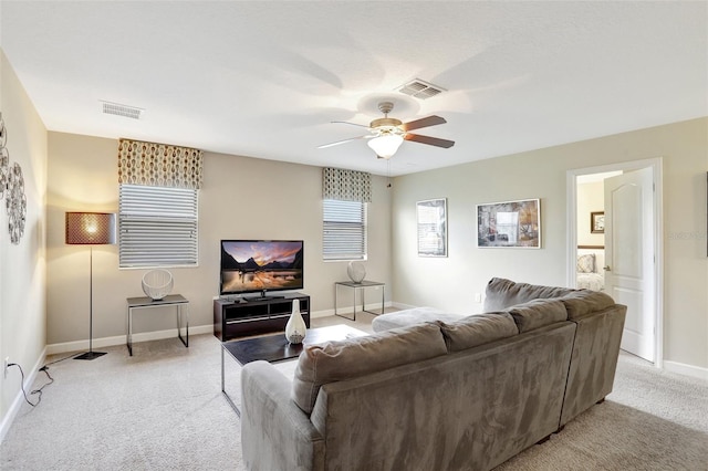 carpeted living room with ceiling fan