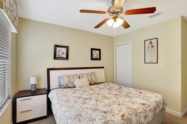 carpeted bedroom featuring ceiling fan and a closet