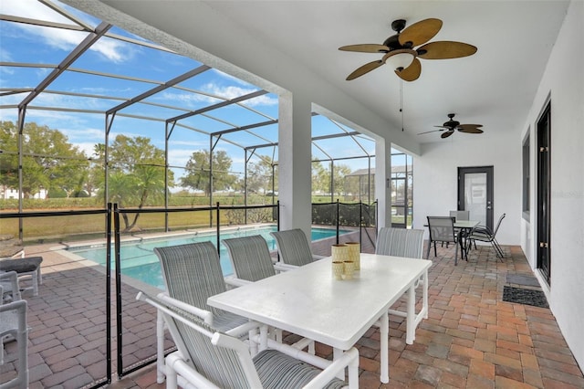 view of patio featuring ceiling fan and glass enclosure