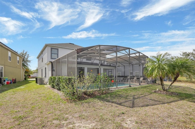 back of property featuring a yard, central AC, and glass enclosure