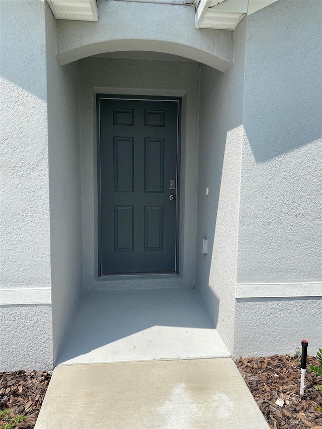 property entrance featuring stucco siding