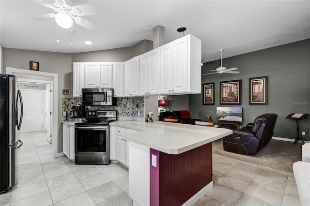 kitchen with white cabinetry, appliances with stainless steel finishes, a kitchen breakfast bar, and kitchen peninsula