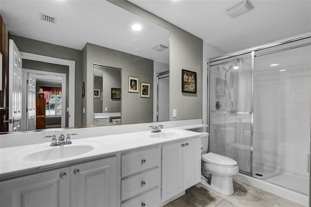 bathroom featuring vanity, toilet, and a shower with door