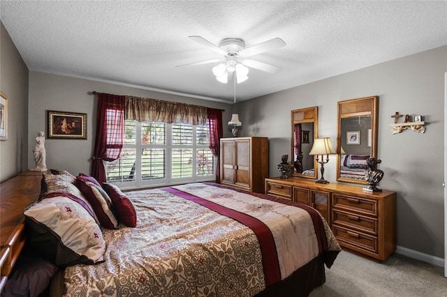 carpeted bedroom featuring ceiling fan and a textured ceiling