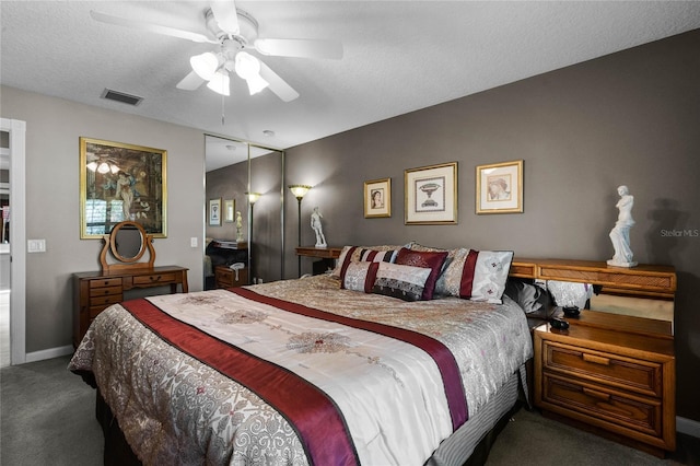 carpeted bedroom featuring ceiling fan and a textured ceiling