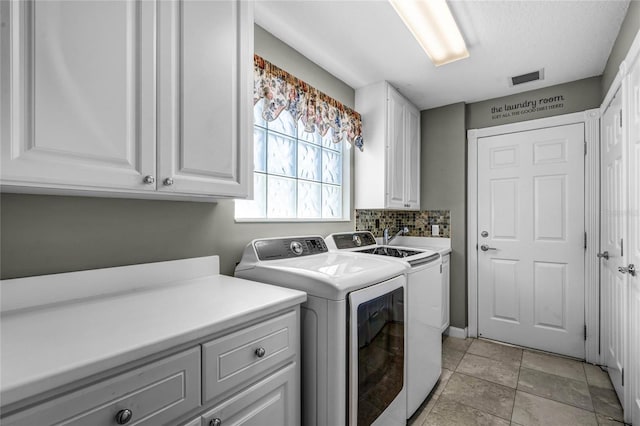 laundry area featuring cabinets and washing machine and dryer