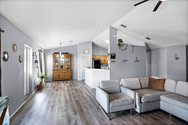 living room with vaulted ceiling, hardwood / wood-style floors, ceiling fan, and a textured ceiling