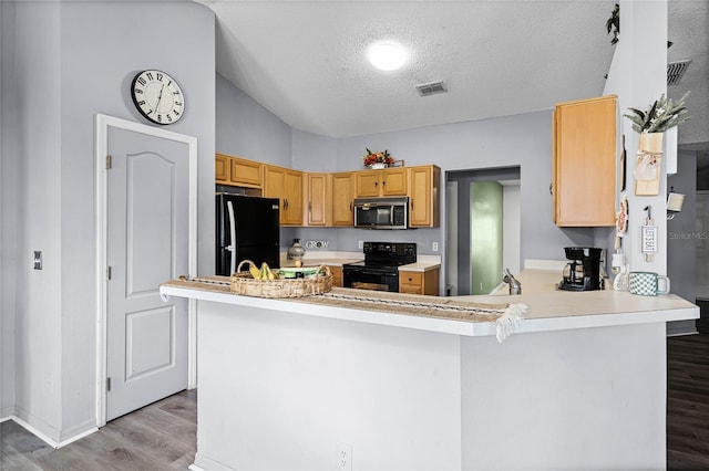 kitchen with black appliances, lofted ceiling, kitchen peninsula, a textured ceiling, and light hardwood / wood-style flooring