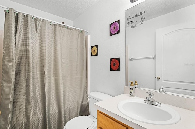 bathroom with vanity, curtained shower, toilet, and a textured ceiling