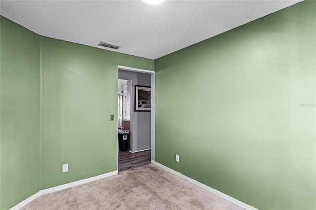 carpeted spare room featuring a textured ceiling