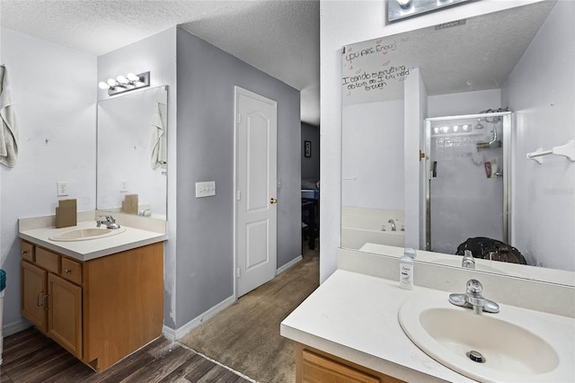 bathroom featuring hardwood / wood-style flooring, vanity, independent shower and bath, and a textured ceiling