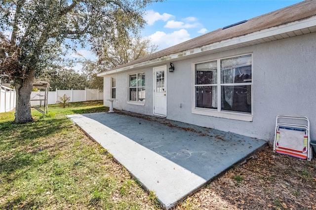 doorway to property with a patio and a lawn