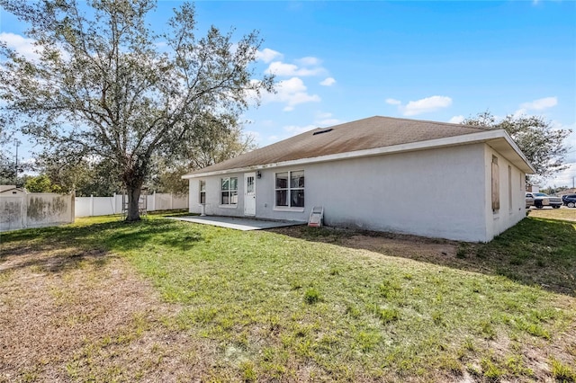 rear view of house featuring a yard and a patio