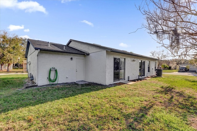 view of property exterior with a yard and central air condition unit