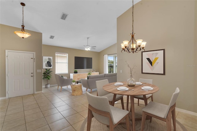 tiled dining space with ceiling fan with notable chandelier and vaulted ceiling