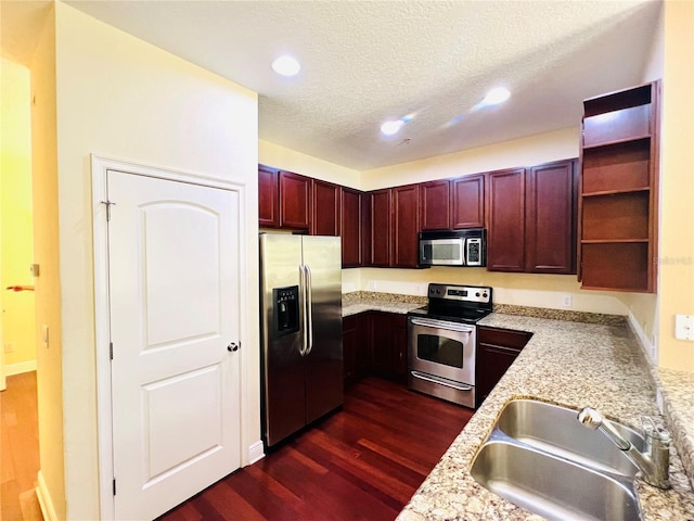 kitchen featuring light stone counters, sink, dark hardwood / wood-style floors, and appliances with stainless steel finishes