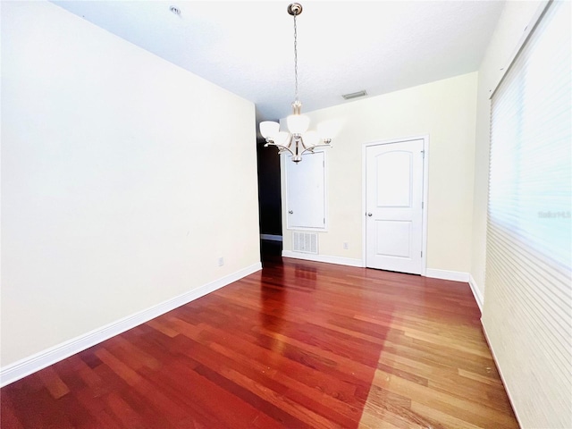 unfurnished dining area featuring a notable chandelier and hardwood / wood-style flooring