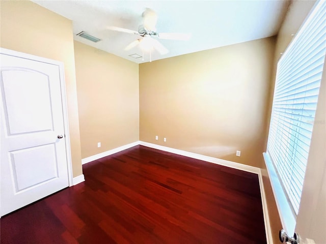 spare room featuring dark wood-type flooring and ceiling fan