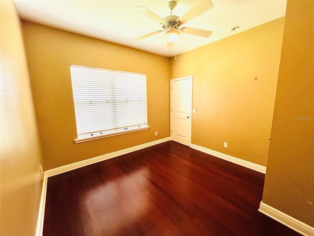 spare room with dark wood-type flooring and ceiling fan