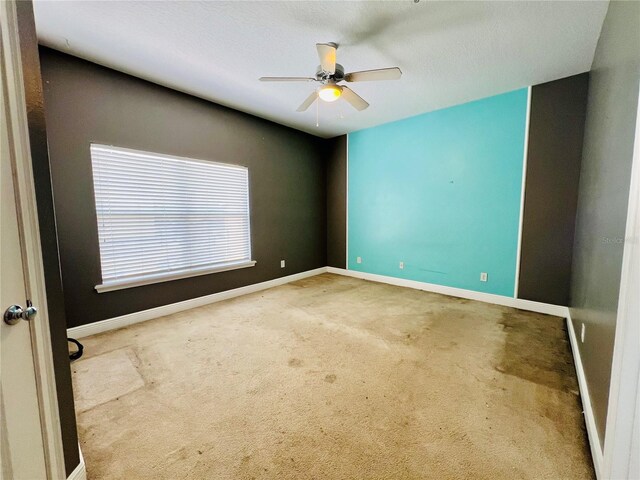 spare room featuring ceiling fan and carpet