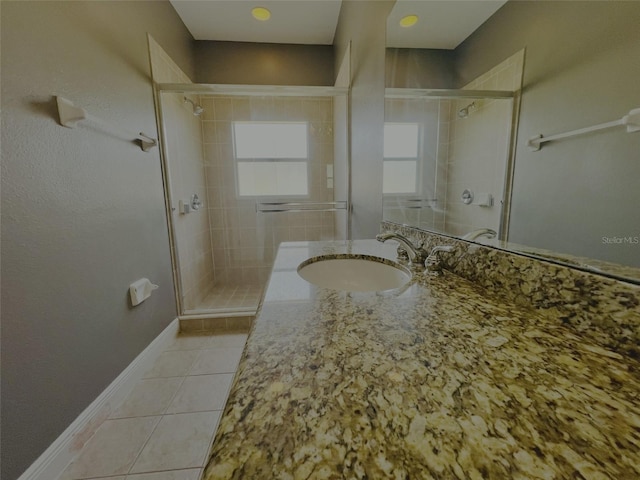 bathroom featuring tile patterned flooring, vanity, and walk in shower