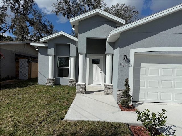 doorway to property with a garage and a lawn