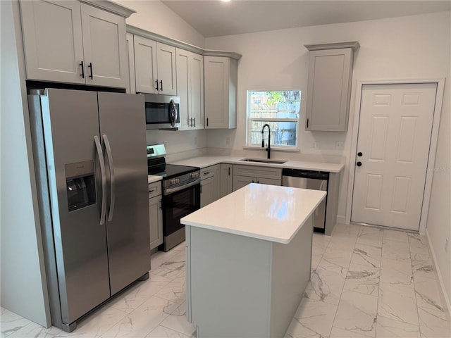 kitchen featuring sink, gray cabinets, stainless steel appliances, and a kitchen island