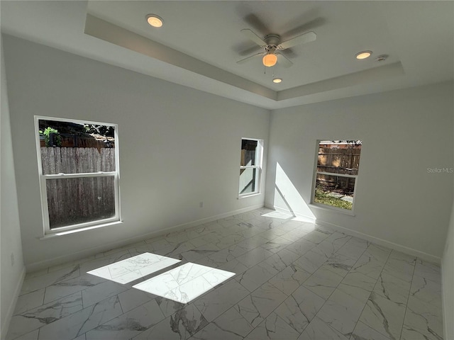 unfurnished room featuring a tray ceiling and ceiling fan