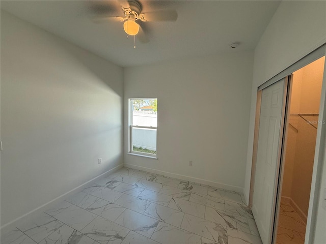 unfurnished bedroom with ceiling fan and a closet