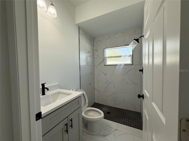 bathroom with vanity, toilet, and tiled shower