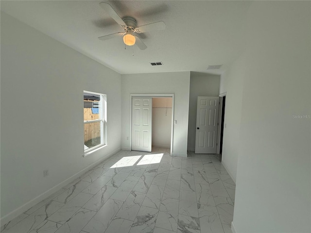 unfurnished bedroom with ceiling fan and a closet