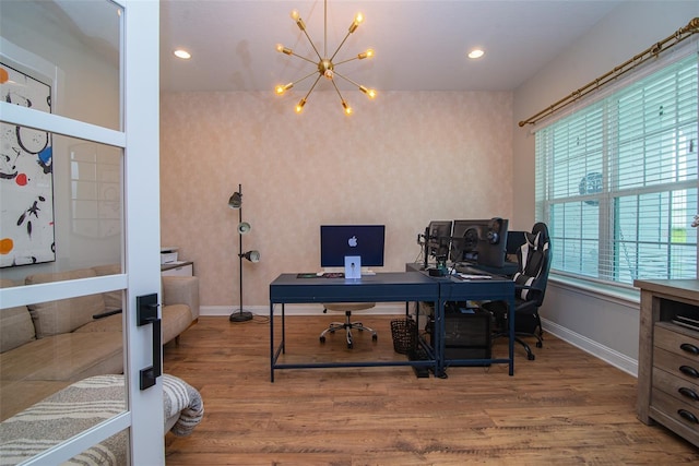 home office with wood-type flooring and a notable chandelier