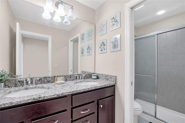 bathroom with a shower with door, vanity, an inviting chandelier, and toilet