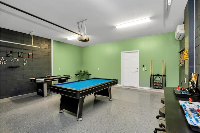 recreation room featuring a wall mounted air conditioner, pool table, and a textured ceiling