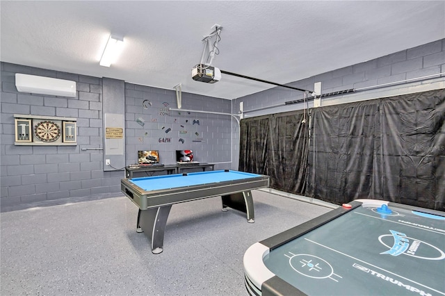 game room with pool table, a textured ceiling, and a wall unit AC