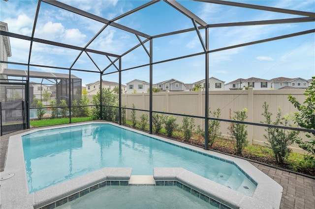 view of swimming pool with a lanai and an in ground hot tub