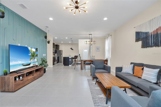 living room featuring light tile patterned flooring and a notable chandelier