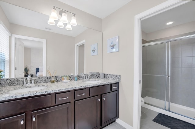 bathroom with a shower with door, an inviting chandelier, vanity, tile patterned floors, and toilet