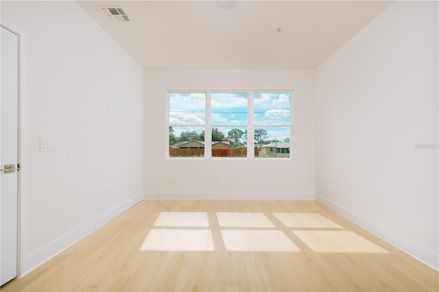 unfurnished room featuring visible vents, baseboards, and light wood-style floors