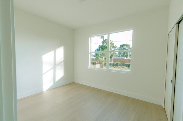 empty room with baseboards and light wood-style flooring