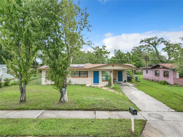 single story home featuring a front yard and solar panels