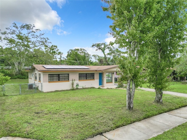 ranch-style home featuring central AC, a front lawn, and solar panels