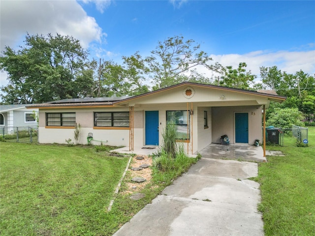 view of front of house featuring a front yard, a carport, and solar panels