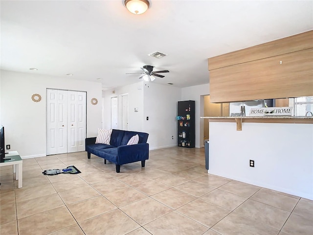 living room with ceiling fan and light tile patterned flooring