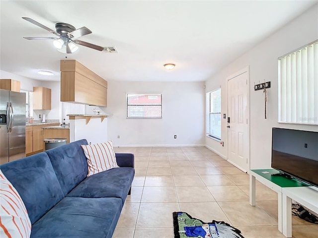 living room featuring light tile patterned floors and ceiling fan