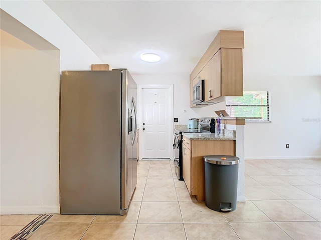 kitchen featuring light stone counters, light tile patterned floors, stainless steel appliances, and light brown cabinets