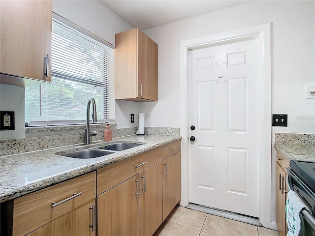 kitchen with sink, light tile patterned floors, electric range, and light stone counters