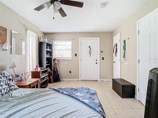 tiled bedroom featuring ceiling fan