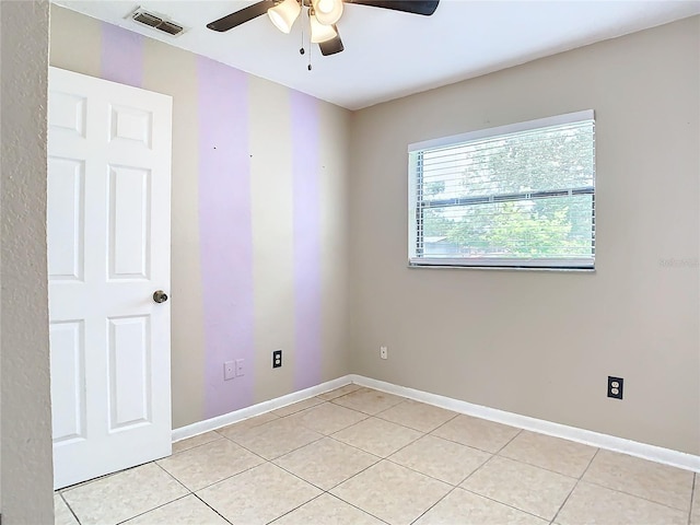 empty room with ceiling fan and light tile patterned floors