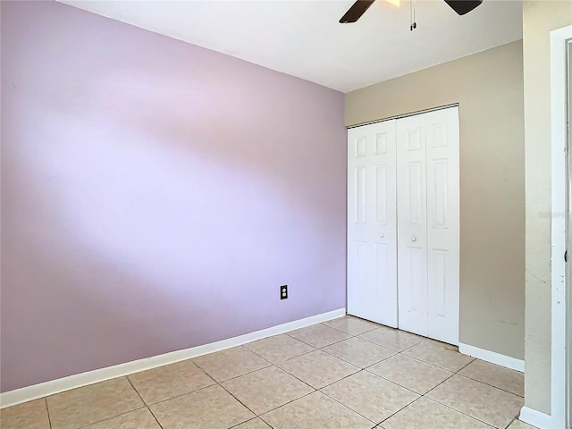 unfurnished bedroom featuring a closet, ceiling fan, and light tile patterned flooring